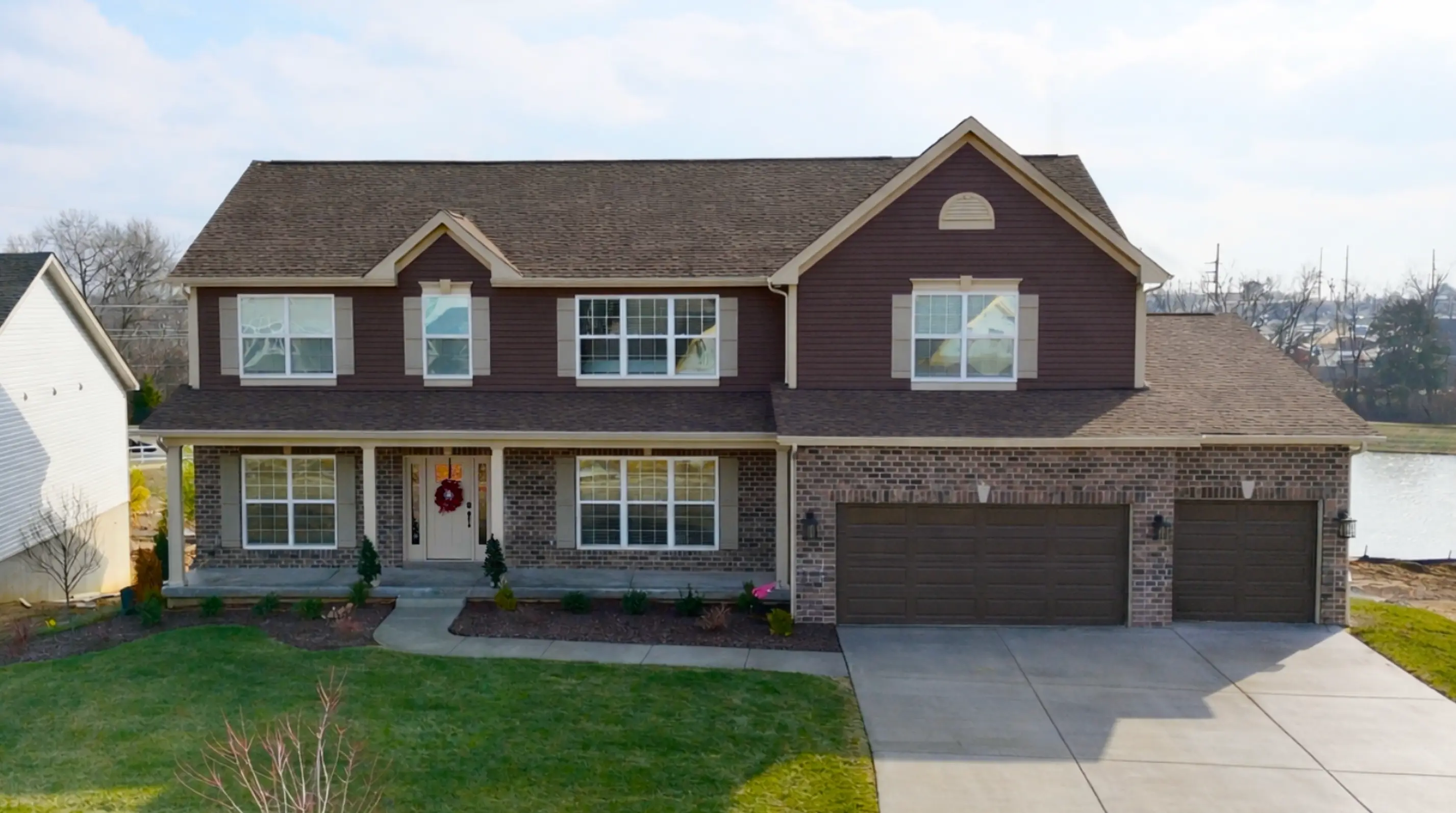 116 Royal Troon, two-story brick-and-siding home on a waterfront lot.